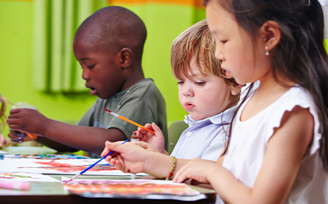 three kids painting in class