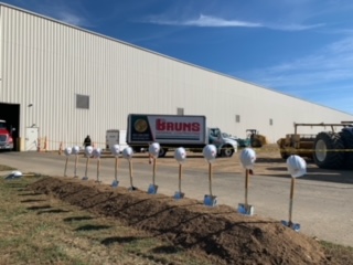 brums warehouse building with golden shovels in a row and white hard hats on top